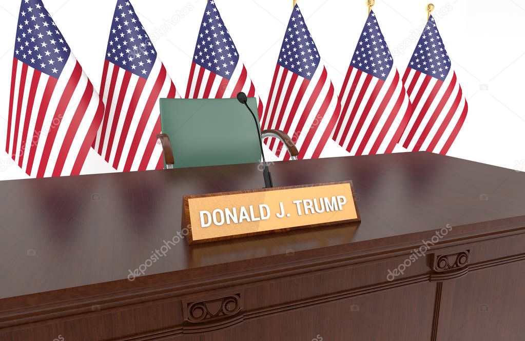 Wooden table with desk plaque DONALD J. TRUMP and American flags.