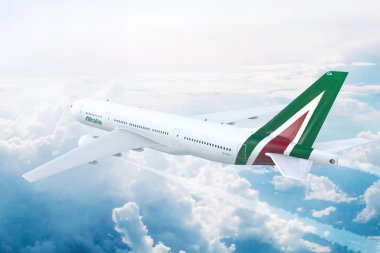 Aerial in-flight view of Alitalia Airlines Boeing 777 flying high above the clouds.  clipart