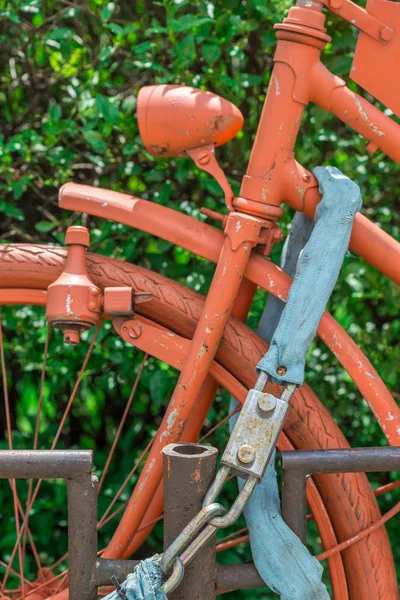 Vintage bike locked and completly painted in orange