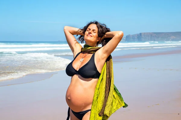 Mujer embarazada feliz en la playa en el océano atlántico — Foto de Stock