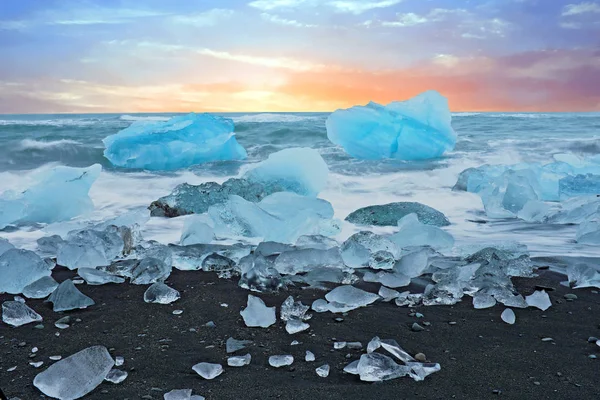 Ledové kameny na černé písečné pláže v Jokulsarlon na Islandu za soumraku — Stock fotografie