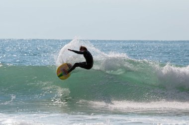 Genç adam onun surfboard Aruba Adası'nda bir dalga yakalar