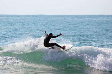 Genç adam onun surfboard Aruba Adası'nda bir dalga yakalar