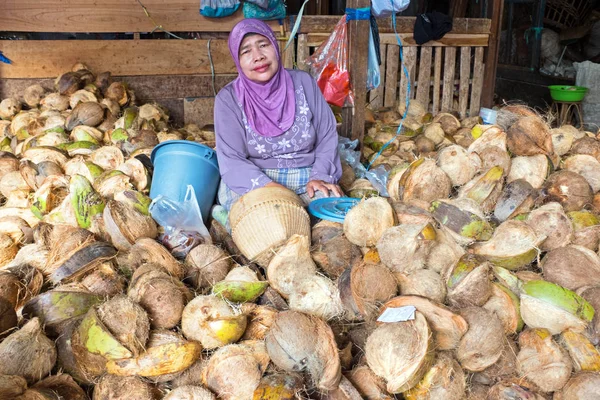 Java, Indonesien - 18. Dezember 2016: Verkäuferin verkauft Kokosnüsse — Stockfoto