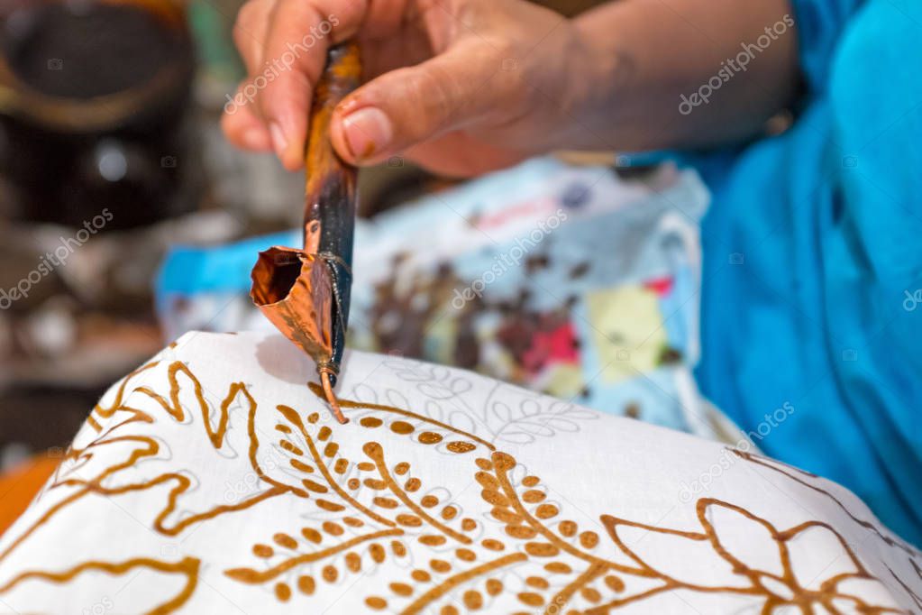 Painting watercolor on the fabric to make Batik. Batik-making is