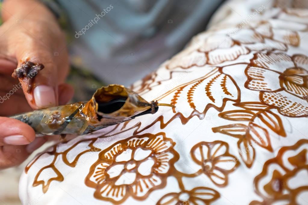 Painting watercolor on the fabric to make Batik Batik-making is 