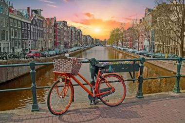 Gün batımında Hollanda Amsterdam şehir merkezinde turuncu bisiklet