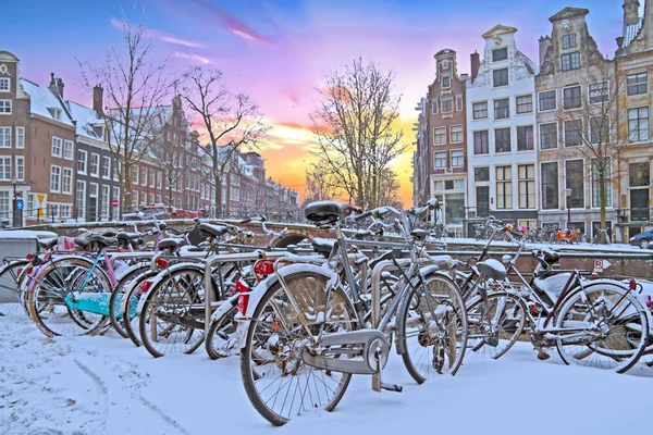Snöiga cyklar i Amsterdam Nederländerna vid solnedgången — Stockfoto