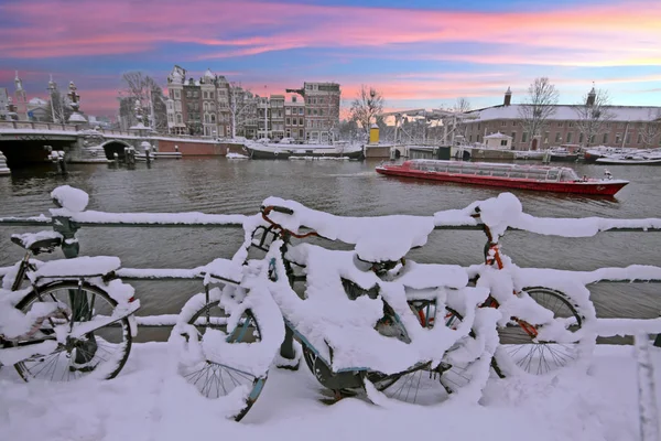 Puesta de sol en Ámsterdam nevada en los Países Bajos en el Amstel en wi —  Fotos de Stock