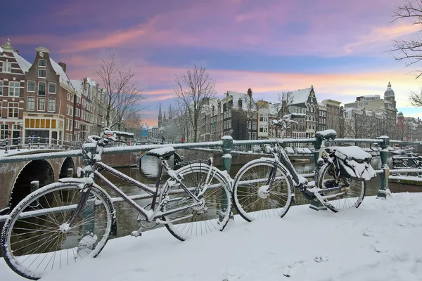 Biciclette innevate nel centro di Amsterdam Paesi Bassi al tramonto — Foto Stock