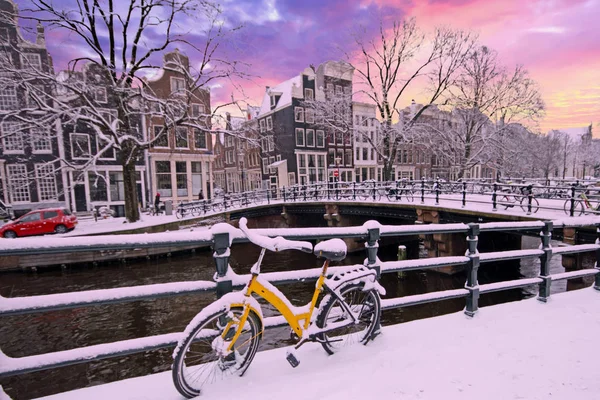 Amsterdam är täckt av snö på vintern vid solnedgången i Nederländerna — Stockfoto