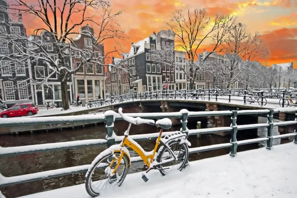 Amsterdam är täckt av snö på vintern vid solnedgången i Nederländerna — Stockfoto