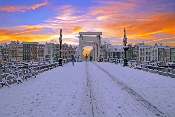 Snowy Amsterdam with the Thiny bridge in the Netherlands at suns — Stock Photo, Image