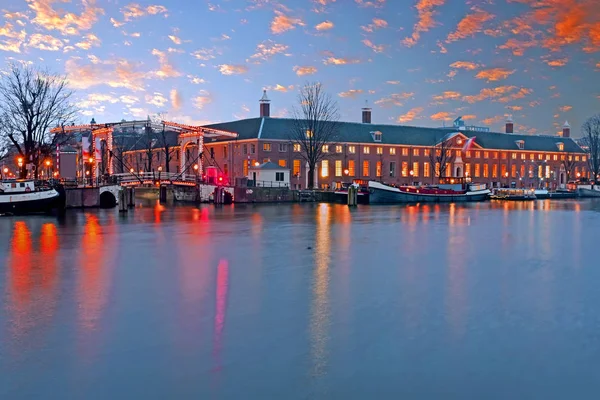 Cidade cênica no rio Amstel em Amsterdã ao pôr do sol — Fotografia de Stock