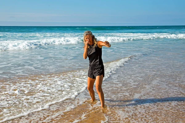 Deportiva mujer madura haciendo kickbox entrenamiento en la playa en el —  Fotos de Stock