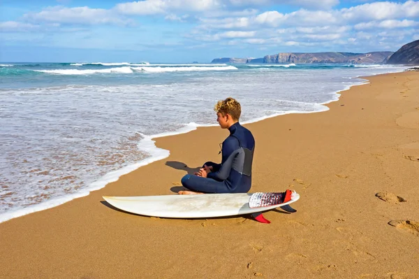 Jovem olhando para as ondas antes de surfar — Fotografia de Stock