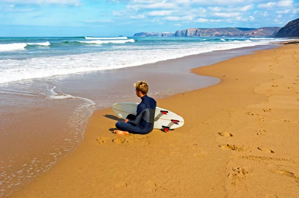 Junger Kerl beobachtet die Wellen, bevor er am Atlantik surft — Stockfoto
