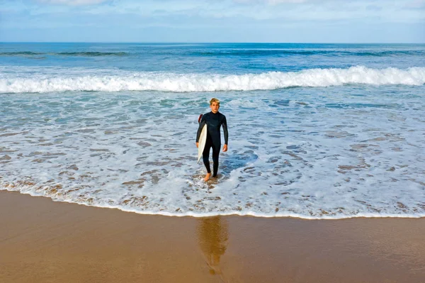 Aerial de um jovem surfista pronto para surfar no oceano atlântico — Fotografia de Stock
