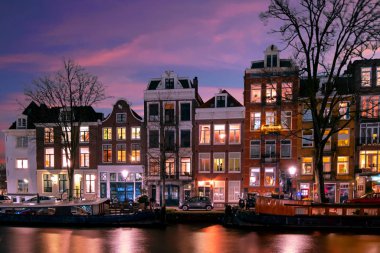 Gün batımında Hollanda 'daki kanal boyunca Amsterdam' daki evler