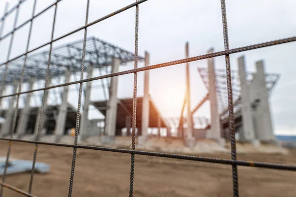 Workers build a new stadion. Concrete and steel building. Construction with a crane