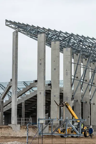 Workers build a new stadion. Concrete and steel building. Construction with a crane