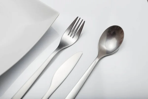 白いテーブルの上でかわいい ミニマルなデザインのフォーク ナイフ スプーンをクリア ホワイトの背景に — ストック写真