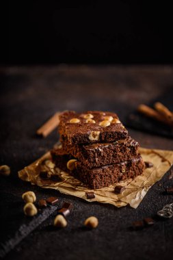 Koyu çikolata ve kakaolu kek açık gri beton masa, çikolata ve fındık parçaları.