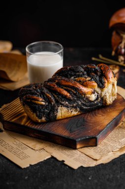 Babka keki ya da eski ahşap tabakta haşhaş tohumlu brioche, lezzetli girdaplı ekmek