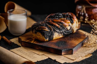 Babka keki ya da eski ahşap tabakta haşhaş tohumlu brioche, lezzetli girdaplı ekmek