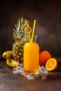 Lezzetli soğuk portakal suyu kokteyl bardağında ananas, kivi ve muzlu içecek.