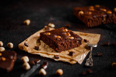 Brownie cake esprisi fındık ve çikolatalı siyah grunge masası.