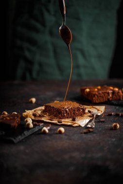 Brownie cake esprisi fındık ve çikolatalı siyah grunge masası.