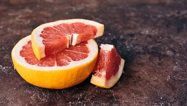 Reife Rote Grapefruit Scheiben Geschnitten Auf Braunem Hintergrund lizenzfreie Stockbilder