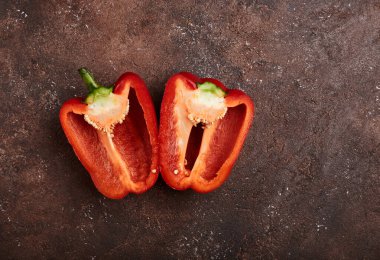 Kahverengi arka planda ikiye bölünmüş taze kırmızı biber.