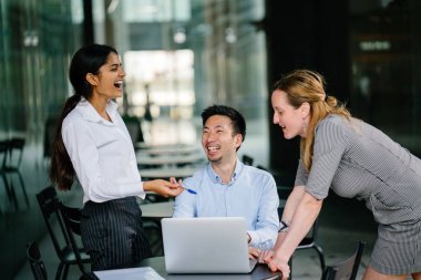 farklı bir takım 3 kişi bir dizüstü bilgisayar etrafında bir tartışma gün açık bir alanda yaşıyorsanız. Gülümse ve konuşmak gibi enerjik ve neşeli vardır.