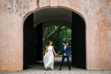  bir takım elbise dansları yakışıklı Hintli adam gün boyunca Asya'da bir parkta Çin onun nişanlısı ile. Irklararası çift yeni nişanlı ve alarak düğün fotoğrafları parkta olduğunu.