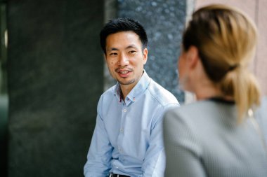 Farklı bir takım iki arkadaşları ofislerine veya şehrin uzayda coworking gün bir tartışma var. Onlar profesyonel olarak giyinmiş ve gülümseyen ve speak olarak güneşin tadını.