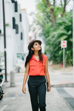 Bir genç Hintli Asya portresi model fedora şapka ayakta Asya sokakta giyiyor. O gülümseyen ve uzak gün arıyorum ve zarif, güzel ve uzun boylu.