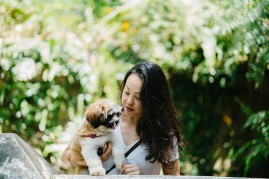 Parkta onun shih tzuh köpek olan bir genç, çekici pan Asya kadın portresi. Onlar ortasında bir yürüyüş ve neşeli ve rahat görünüyorlar.