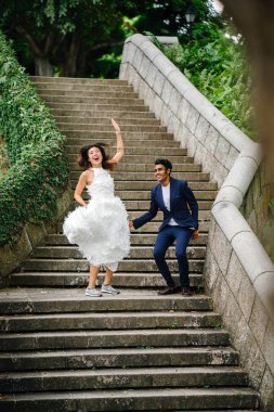 gün boyunca parkta taş basamaklar üzerinde Interracial aşıklar çifti. Bir Hintli bir Çinli kadın zevk ve neşe içinde evleniyor.