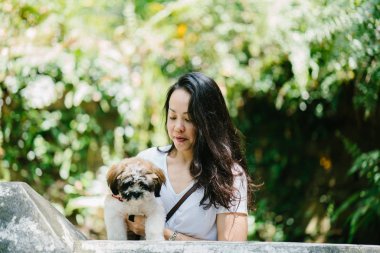 Parkta onun shih tzuh köpek olan bir genç, çekici pan Asya kadın portresi. Onlar ortasında bir yürüyüş ve neşeli ve rahat görünüyorlar.