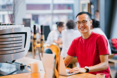 laptop bir kafede Asya Orta yaşlı adam (Çince veya Japonca) çalışma.