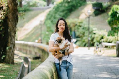 Parkta onun shih tzuh köpek olan bir genç, çekici pan Asya kadın portresi. Onlar ortasında bir yürüyüş ve neşeli ve rahat görünüyorlar.