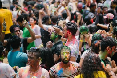 Singapur, 3 Mart 2018: Sentosa Island, Singapur bayram kutlama. Hintliler ve diğer kutlama renkli hamur ve toz birbirlerine yayma ve güneşin büyük bir havuzu müzik dans.