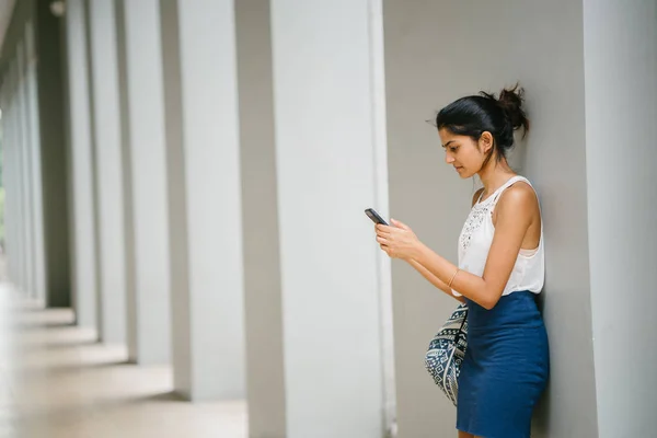 プロ服を着ている女性が魅力的で若いインドの肖像画 彼女はスマート フォンで立っています — ストック写真