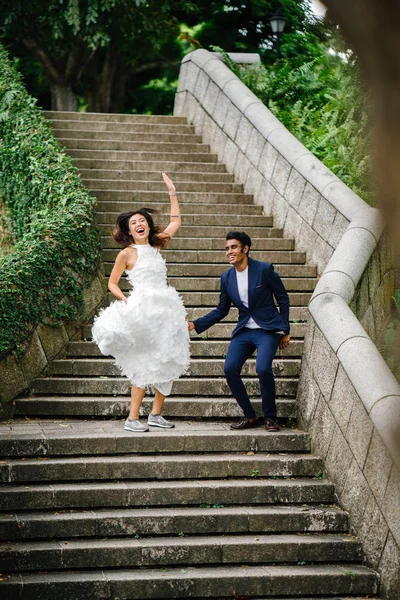 gün boyunca parkta taş basamaklar üzerinde Interracial aşıklar çifti. Bir Hintli bir Çinli kadın zevk ve neşe içinde evleniyor.
