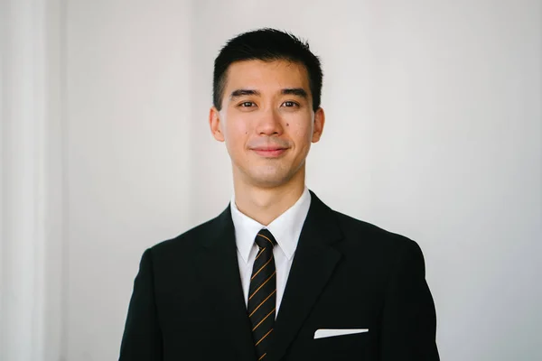 一个英俊 自信和年轻的亚洲男子的肖像头部拍摄的微笑在相机 他穿着深色西装 白衬衫 专业领带 — 图库照片