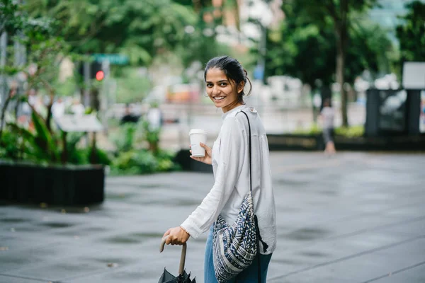 若くて魅力的なインド女性の傘が付いている都市を歩いて — ストック写真