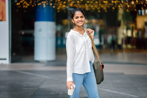カフェ コーヒー ショップ の日にコーヒー カップを持って外に立って笑顔若い インド アジア女性の肖像 — ストック写真