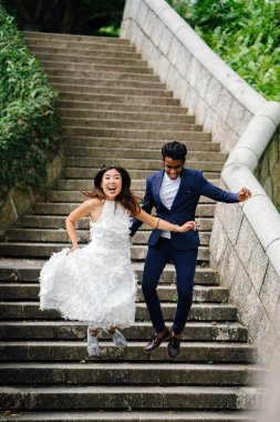 Genç ırklararası çift (Hintli adam, Çinli kadın) Fort Canning Parkı, Singapur'da düğün fotoğraf çekmek. 